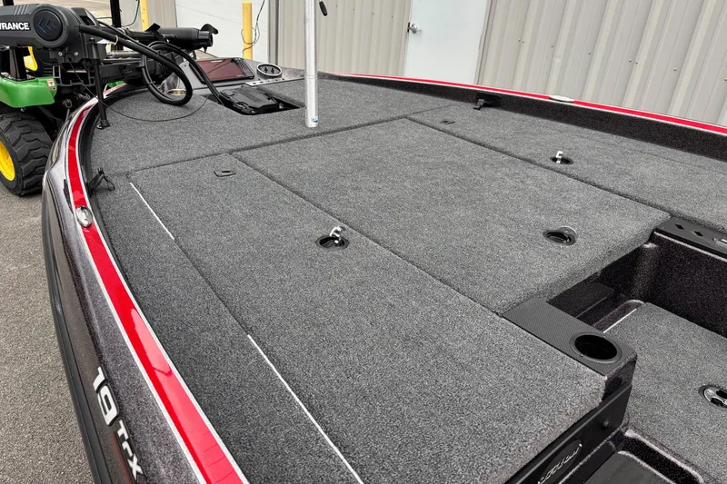 Slide: The Image of 2026 Triton 19 TrX Patriot boat deck with gray carpet and red trim. - 4