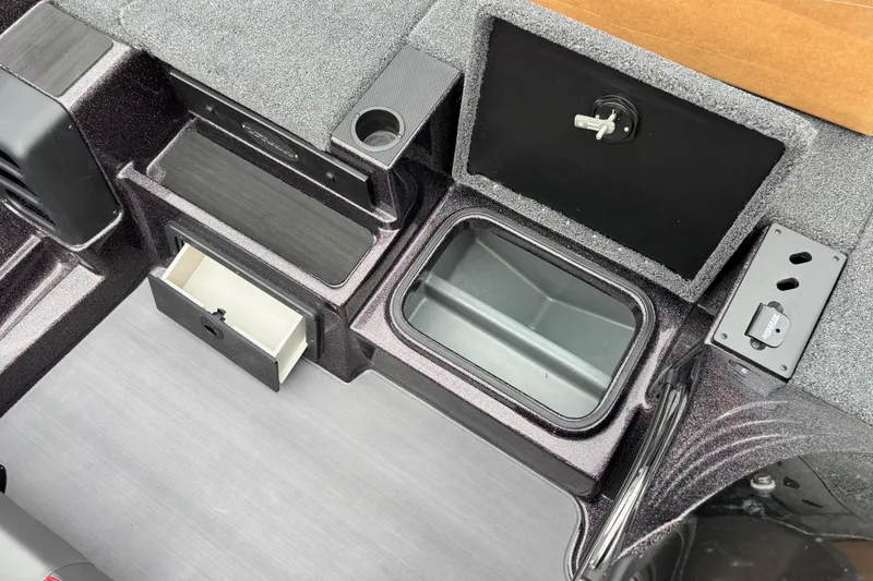 Slide: The Image of 2026 Triton 19 TrX Patriot boat interior with storage compartments and cup holder. - 7