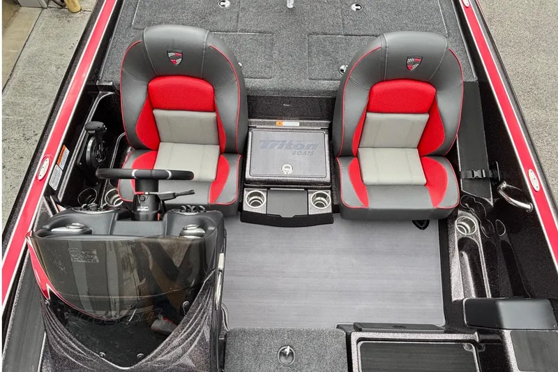 Slide: The Image of 2026 Triton 19 TrX Patriot boat interior with red and gray seating, steering console, and storage. - 8