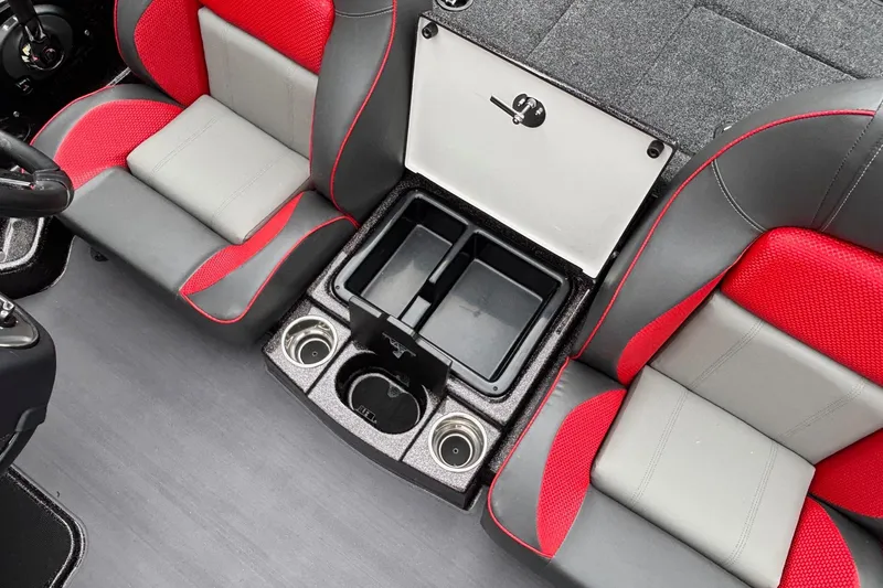 Slide: The Image of 2026 Triton 19 TrX Patriot boat interior with red and gray seats, storage, and cup holders. - 9
