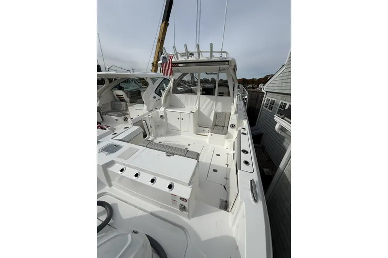 Slide: The Image of 2026 Pursuit OS 325 Offshore boat interior with seating and fishing rod holders. - 2