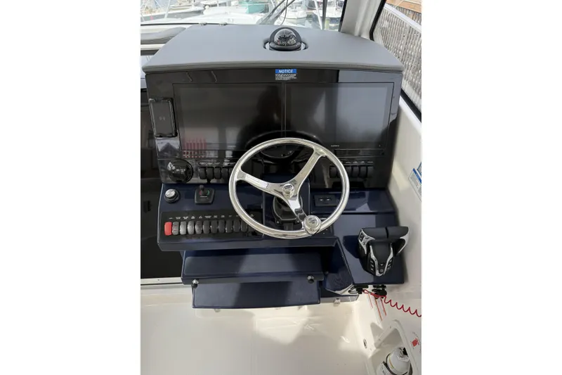 Slide: The Image of Helm of 2026 Pursuit OS 325 Offshore boat with modern controls and steering wheel. - 4