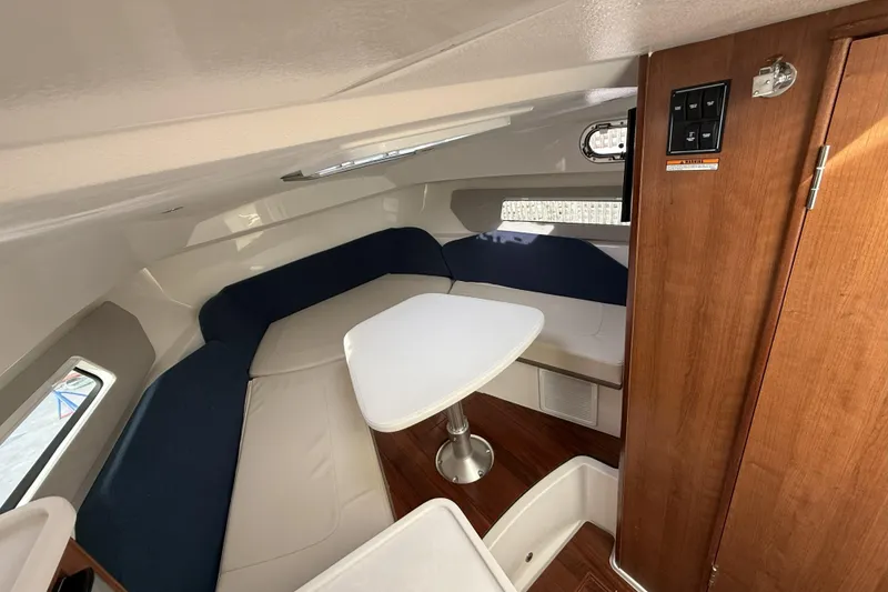 Slide: The Image of 2026 Pursuit OS 325 Offshore cabin interior with seating and table. - 8