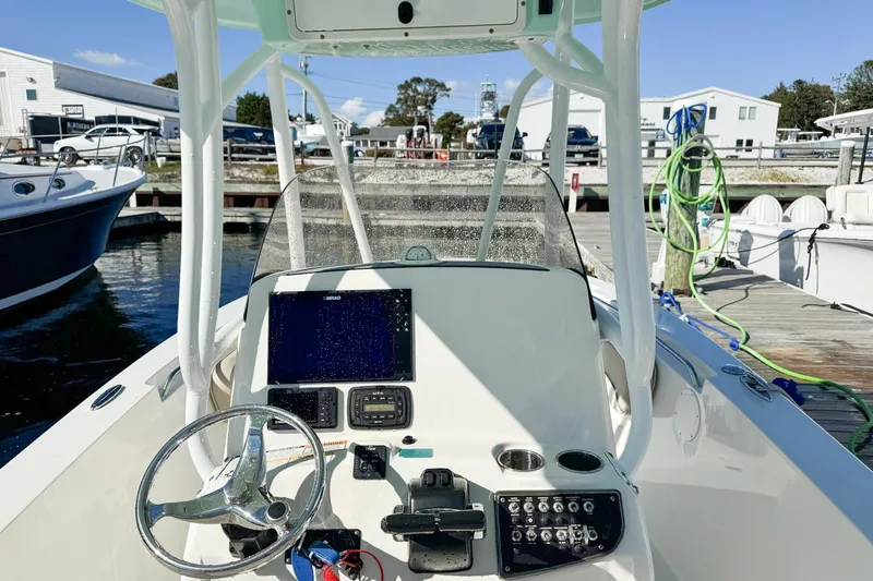Slide: The Image of 2017 NauticStar 2602 Legacy boat dashboard with steering wheel and navigation equipment. - 13