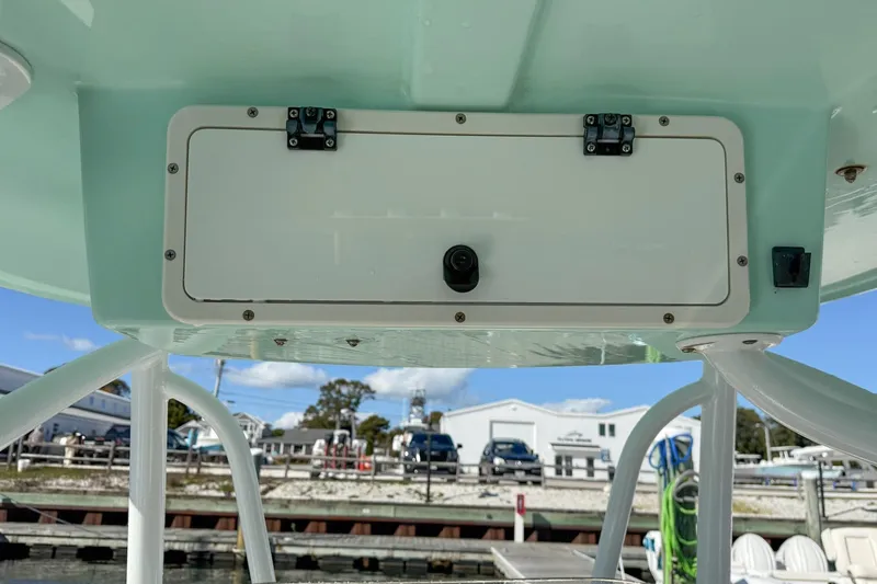 Slide: The Image of 2017 NauticStar 2602 Legacy boat console with storage compartment and camera. - 15