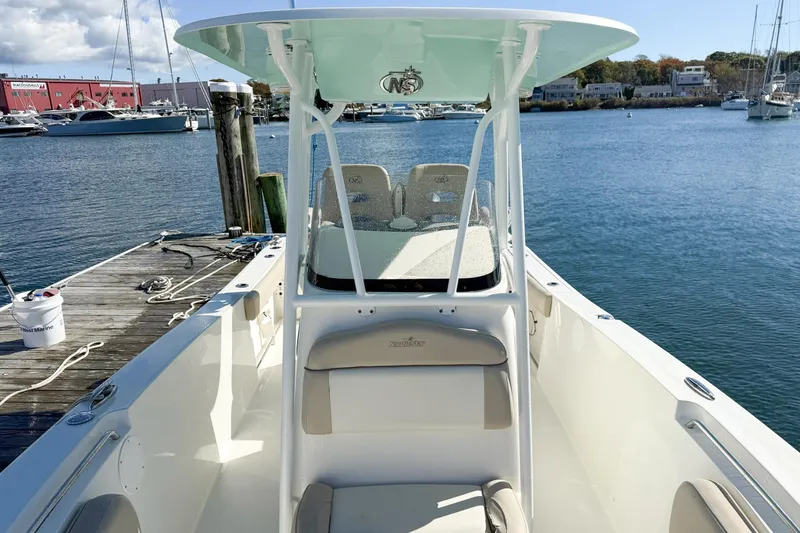 Slide: The Image of 2017 NauticStar 2602 Legacy boat docked by the water, showcasing sleek design. - 9