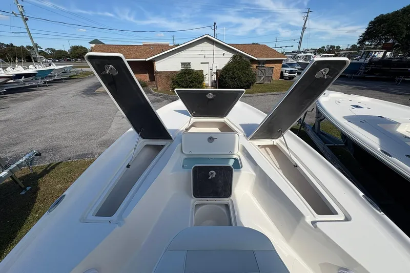Slide: The Image of 2026 Key West 230 Bay Reef boat with open storage compartments, docked outdoors. - 10