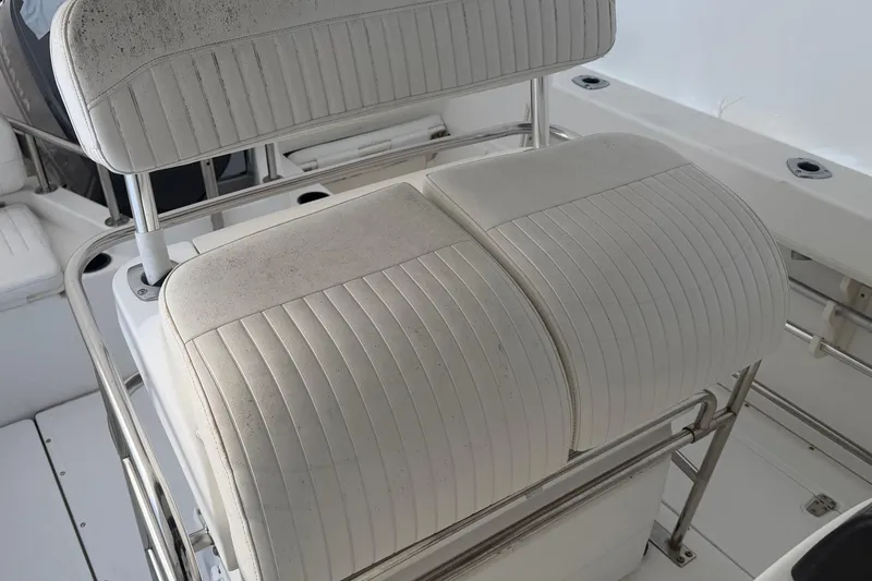 Slide: The Image of Boston Whaler 210 Outrage 1999 boat seating with white cushioned bench and stainless steel frame. - 2