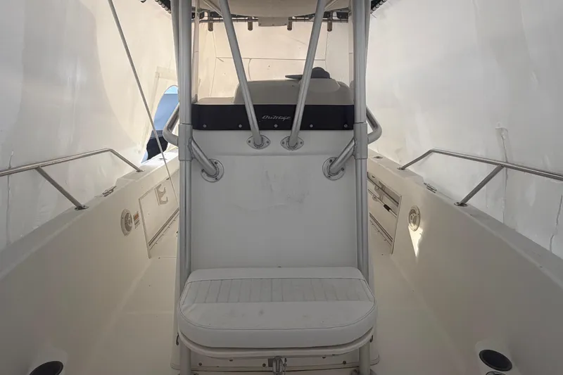 Slide: The Image of 1999 Boston Whaler 210 Outrage interior with seating and console, under protective cover. - 4