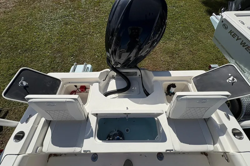 Slide: The Image of 2026 Key West 230 Bay Reef boat interior with open compartments and motor, viewed from above. - 5