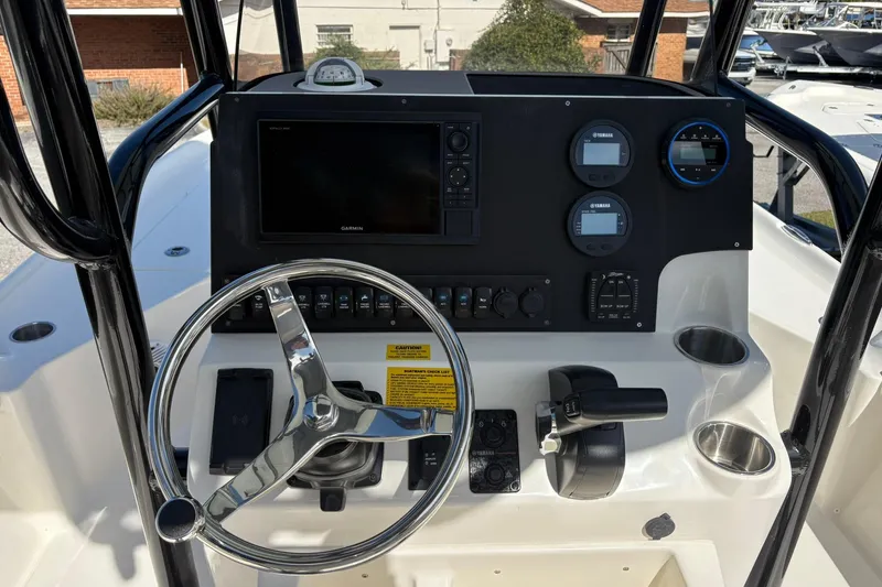 Slide: The Image of 2026 Key West 230 Bay Reef boat dashboard with steering wheel and control panel. - 6