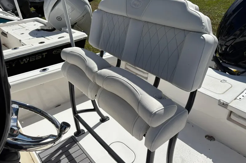 Slide: The Image of 2026 Key West 230 Bay Reef boat with cushioned seating and steering wheel. - 7