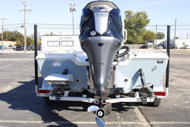 Slide: The Image of 2026 Skeeter SX221 boat with powerful outboard motor, parked in an urban setting. - 19