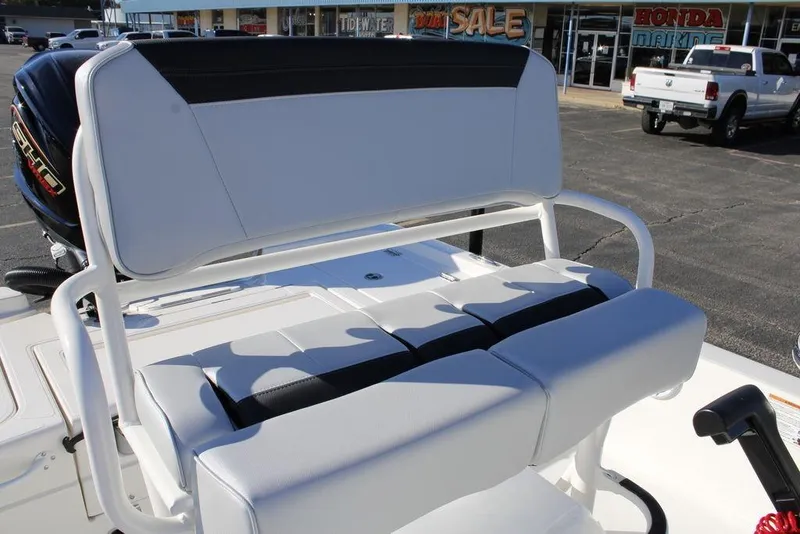 Slide: The Image of 2026 Skeeter SX221 boat seating with white and black upholstery in a dealership lot. - 9