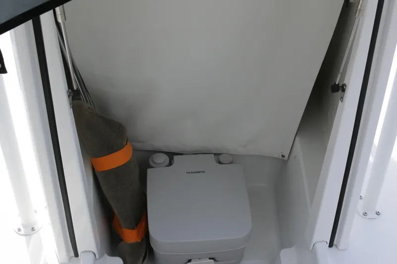 Slide: The Image of 2026 Wellcraft 202 Fisherman boat interior with portable toilet and storage area. - 15