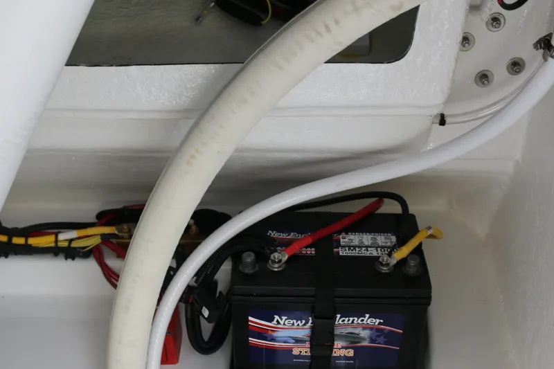 Slide: The Image of Battery compartment of 2026 Wellcraft 202 Fisherman boat, featuring wiring and connections. - 17