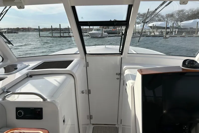 Slide: The Image of 2025 Southport 33 DC boat interior with marina view through windshield. - 6