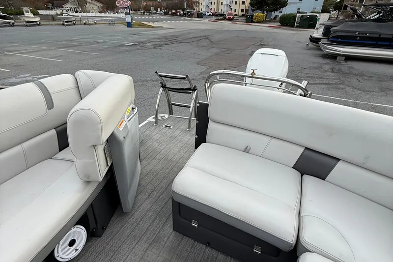 Slide: The Image of 2020 Godfrey AquaPatio 255 UL pontoon boat interior with white seating and dock ladder. - 13