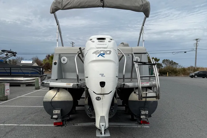Slide: The Image of 2020 Godfrey AquaPatio 255 UL pontoon boat with powerful outboard motor in a parking lot. - 7