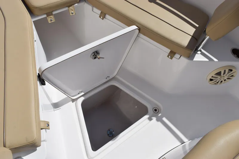 Slide: The Image of 2017 Sportsman Open 232 Center Console boat storage compartment with beige seating. - 15