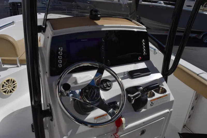 Slide: The Image of 2017 Sportsman Open 232 Center Console boat dashboard with steering wheel and controls. - 9