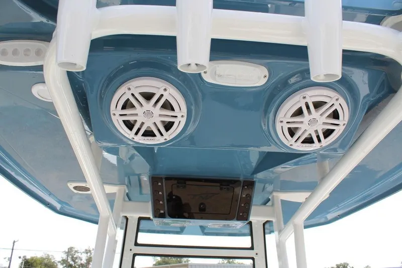 Slide: The Image of 2026 Tidewater 220 CC Adventure boat speakers and rod holders on blue T-top. - 15
