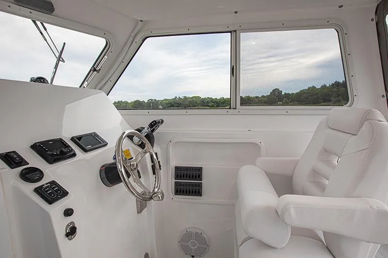 Slide: The Image of Manufacturer Provided Image: Interior of 2026 NorthCoast 255 HT boat, featuring helm and captain's chair. - 12