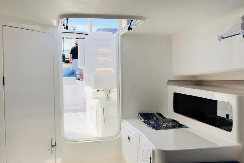 Slide: The Image of Manufacturer Provided Image: Interior view of 2026 NorthCoast 255 HT boat, featuring sleek white cabin design. - 14