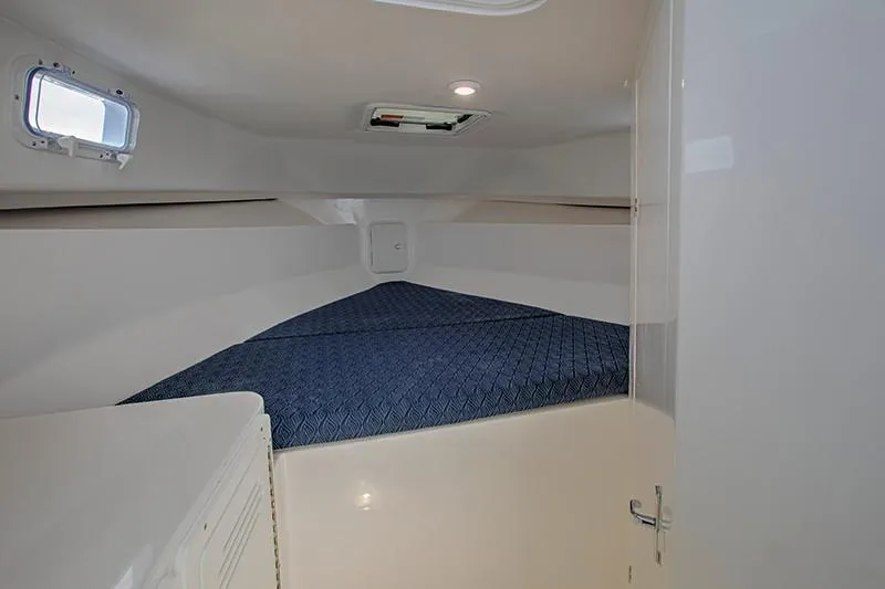 Slide: The Image of Manufacturer Provided Image: 2026 NorthCoast 255 HT cabin interior with blue bedding and small window. - 15
