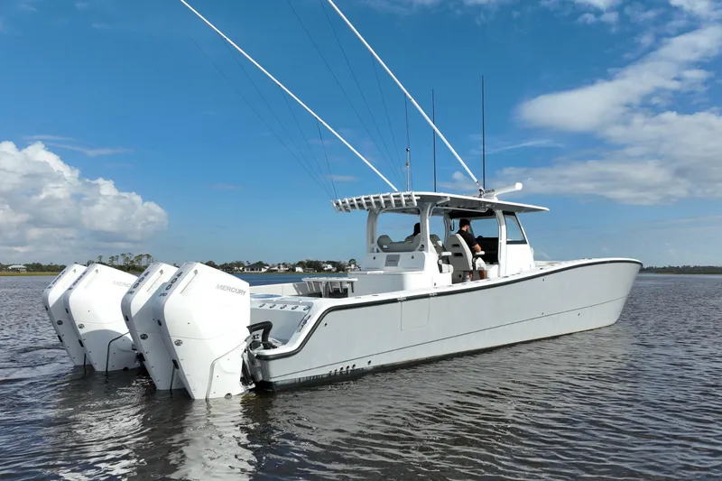 Slide: The Image of 2022 Freeman 47 boat with triple Mercury engines on calm water under blue sky. - 12
