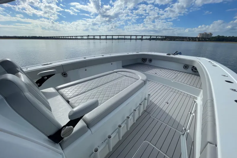 Slide: The Image of Luxurious 2022 Freeman 47 boat interior with cushioned seating, overlooking calm waters and a bridge. - 20