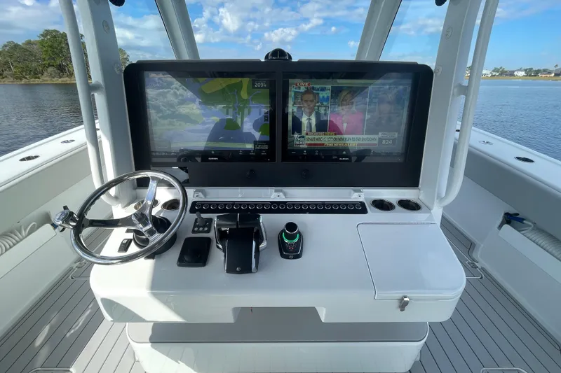 Slide: The Image of 2022 Freeman 47 boat helm with dual screens and steering wheel on water. - 28