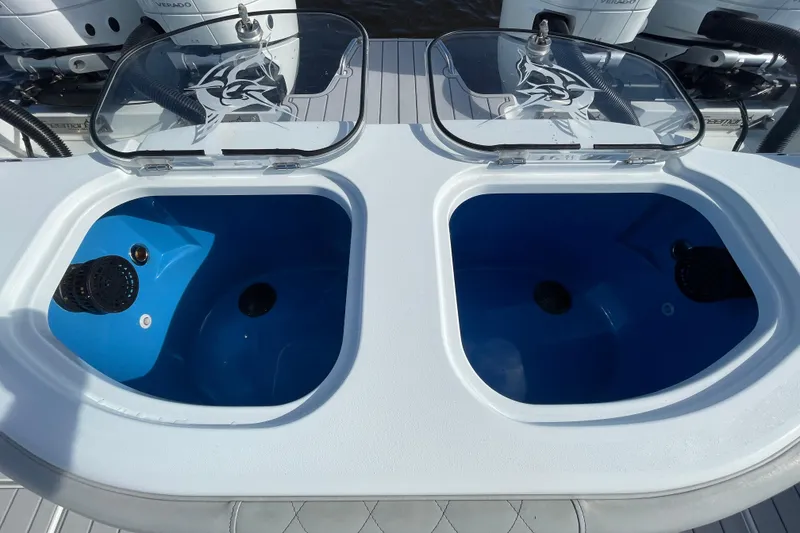 Slide: The Image of Livewell compartments on a 2022 Freeman 47 boat, featuring clear lids and blue interiors. - 43