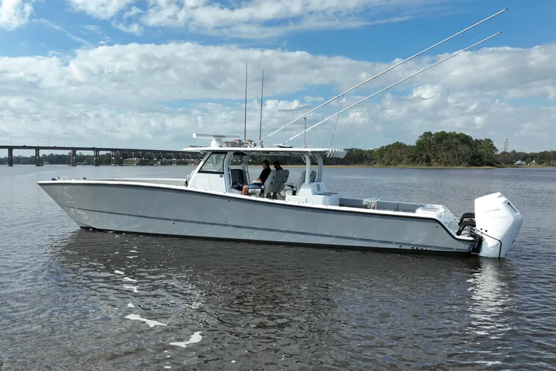 Slide: The Image of 2022 Freeman 47 boat on calm water with bridge and trees in background. - 6