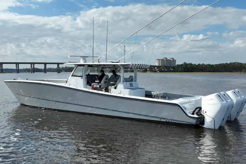 Slide: The Image of 2022 Freeman 47 boat on water with multiple outboard engines, bridge in background. - 7