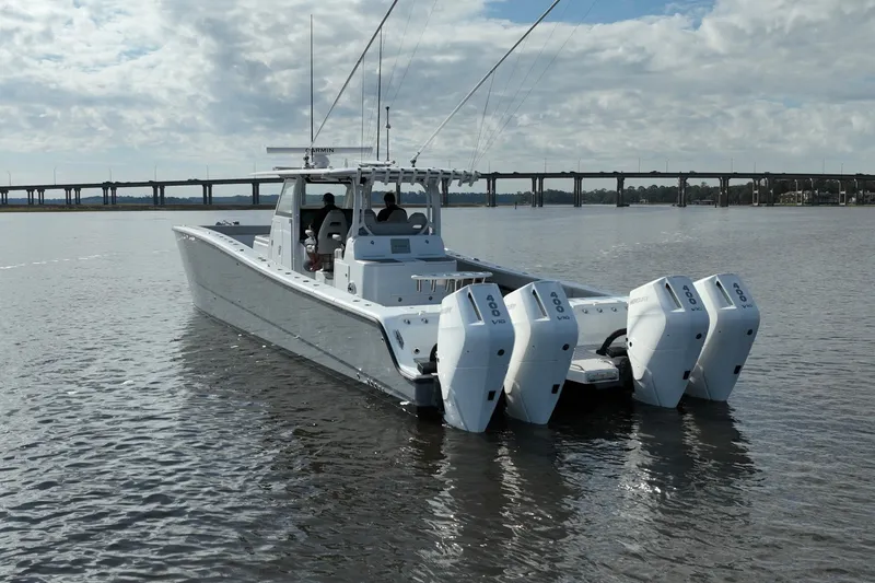 Slide: The Image of 2022 Freeman 47 boat with four engines on calm water, bridge in background. - 9