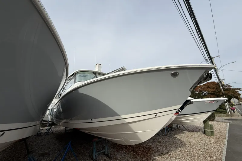 The Image of 2026 Pursuit DC 306 Dual Console boat displayed outdoors on gravel. - 0