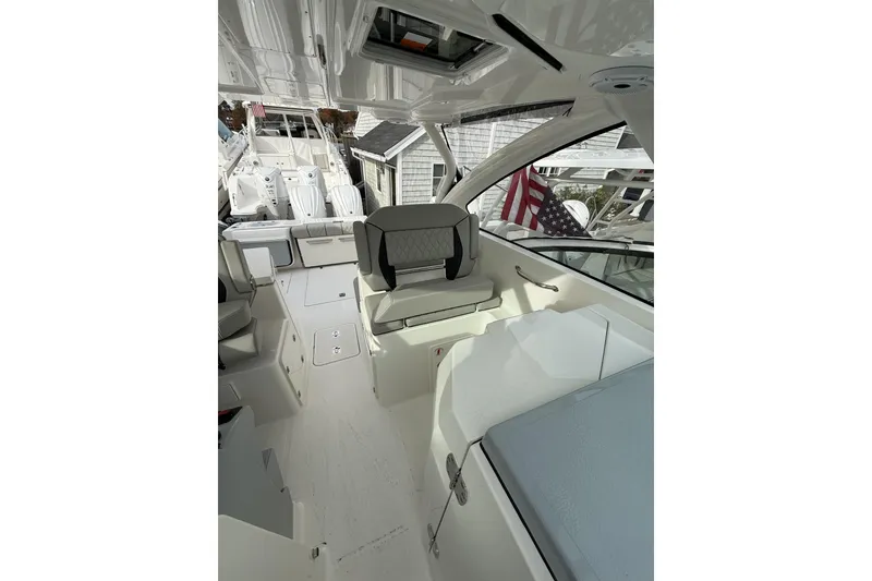 Slide: The Image of 2026 Pursuit DC 306 Dual Console boat interior with seating and American flag. - 11
