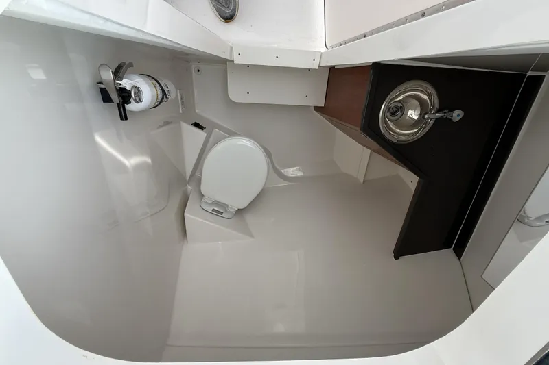 Slide: The Image of 2026 Pursuit DC 306 Dual Console boat interior with toilet and sink. - 12