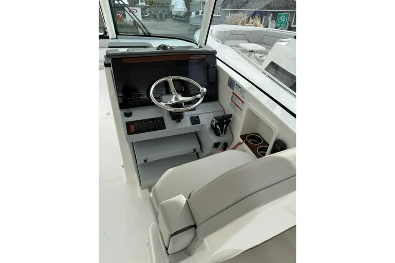 Slide: The Image of 2026 Pursuit DC 306 Dual Console boat helm with steering wheel and controls. - 4