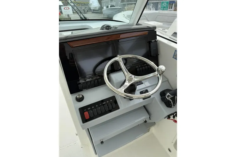 Slide: The Image of Helm of 2026 Pursuit DC 306 Dual Console with steering wheel and controls. - 5
