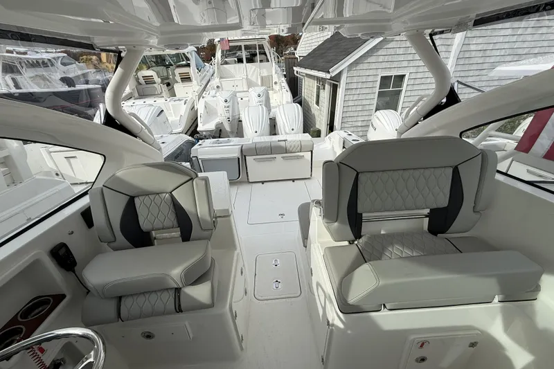 Slide: The Image of 2026 Pursuit DC 306 Dual Console boat interior with modern seating and sleek design. - 7