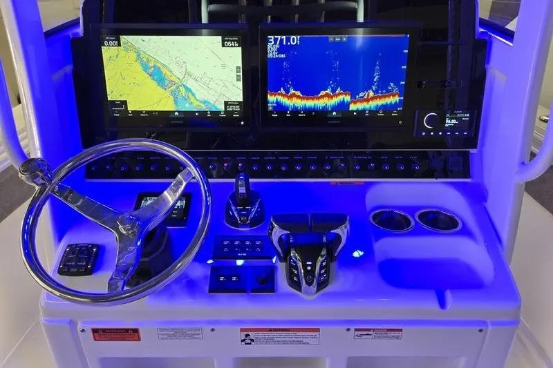 Slide: The Image of 2026 Sea Hunt Ultra 285 SE dashboard with navigation and sonar displays, illuminated in blue. - 9