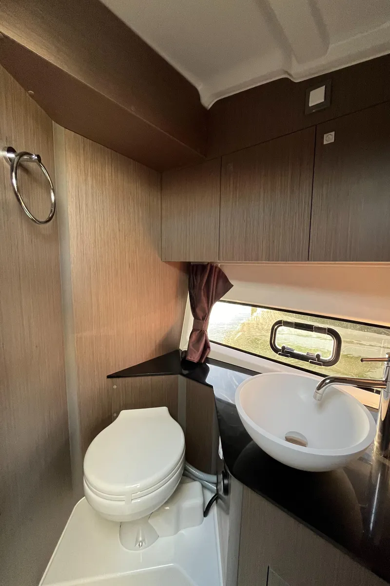 Slide: The Image of 2024 Beneteau Gran Turismo 32 Inboard bathroom with modern sink and toilet. - 21