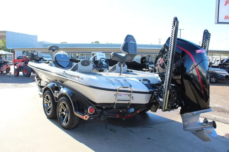 Slide: The Image of 2019 Ranger Z521 Comanche boat with powerful outboard motor, parked on a sunny day. - 2