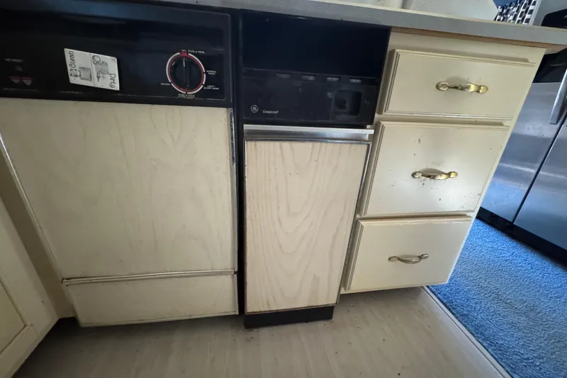 Slide: The Image of Kitchen area of a 1997 Monticello River Yacht, featuring cabinets and a dishwasher. - 10