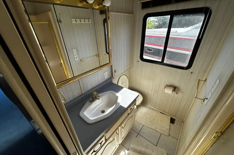 Slide: The Image of Bathroom interior of 1997 Monticello River Yacht, featuring sink, mirror, and window. - 14