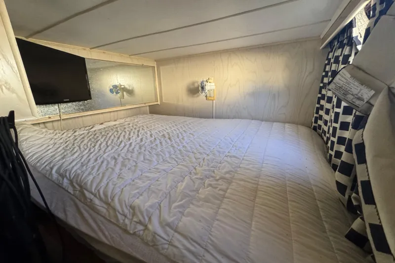 Slide: The Image of Cozy bedroom in 1997 Monticello River Yacht with TV and checkered curtains. - 18