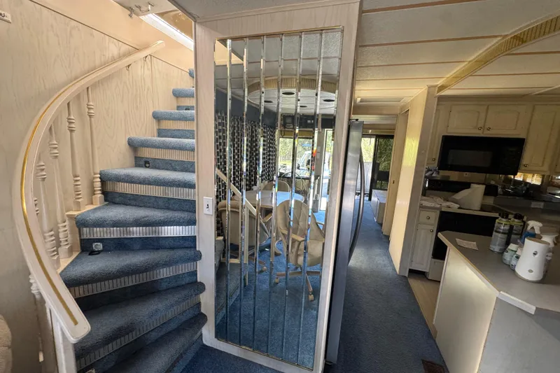 Slide: The Image of Interior of a 1997 Monticello River Yacht, featuring a spiral staircase and modern kitchen. - 2