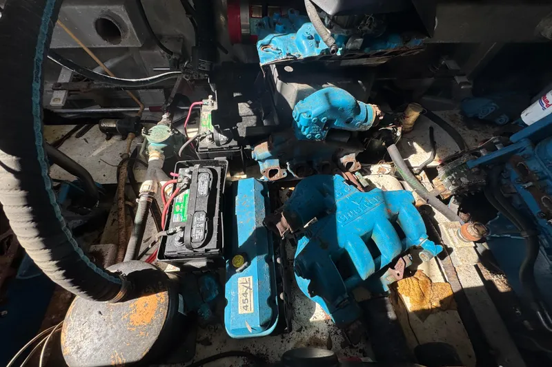 Slide: The Image of Engine compartment of a 1997 Monticello River Yacht, showcasing mechanical components and battery. - 26